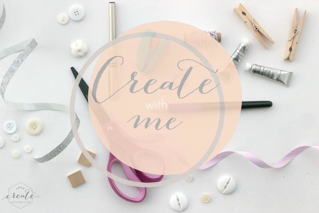 Craft supplies - buttons, ribbons, scissors, and paint - spread out on a white background and image overylay text that reads "Create with Me" 